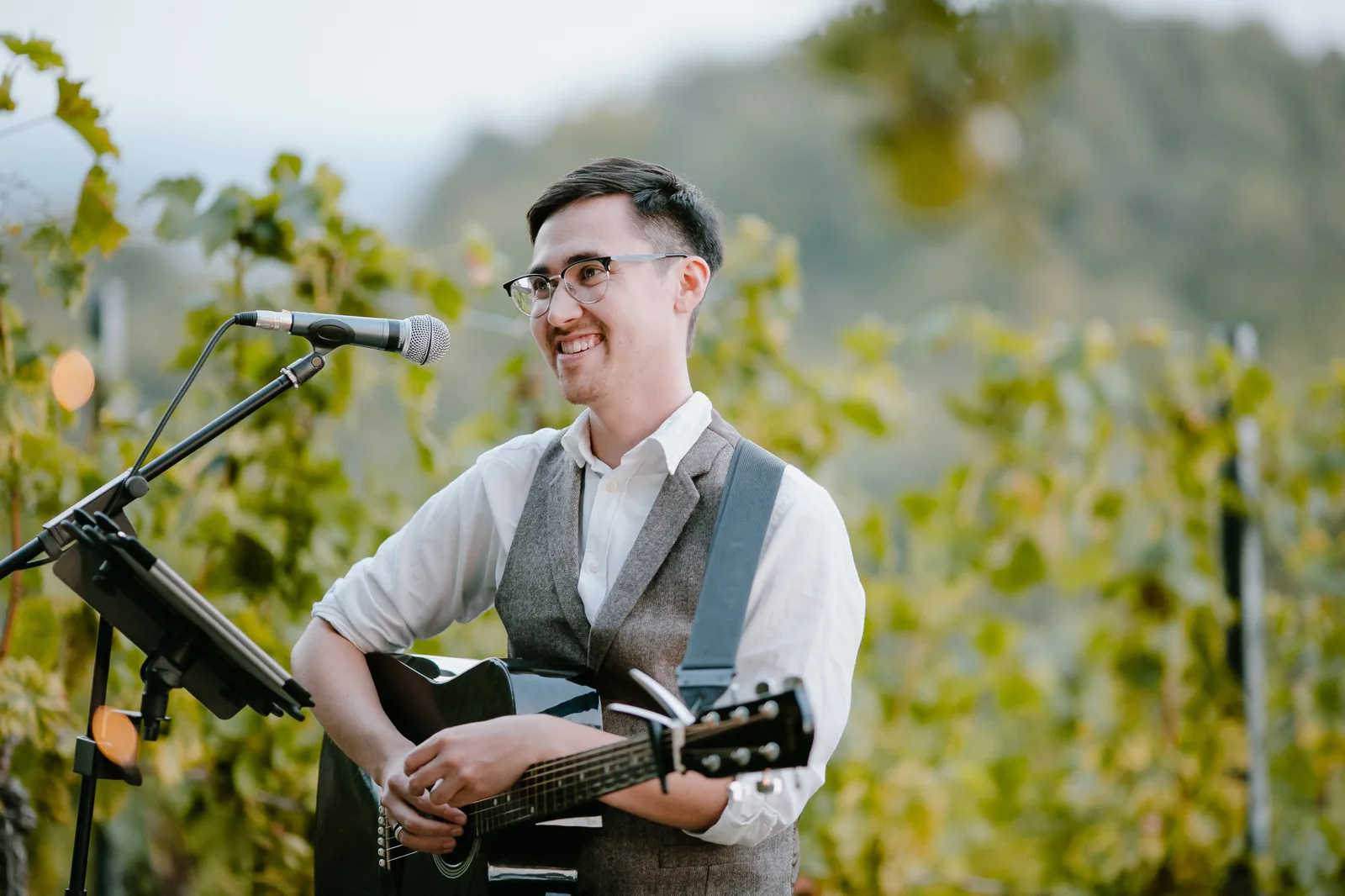 Stephen W. mit Akustikgitarre sitzend im Weinberg
